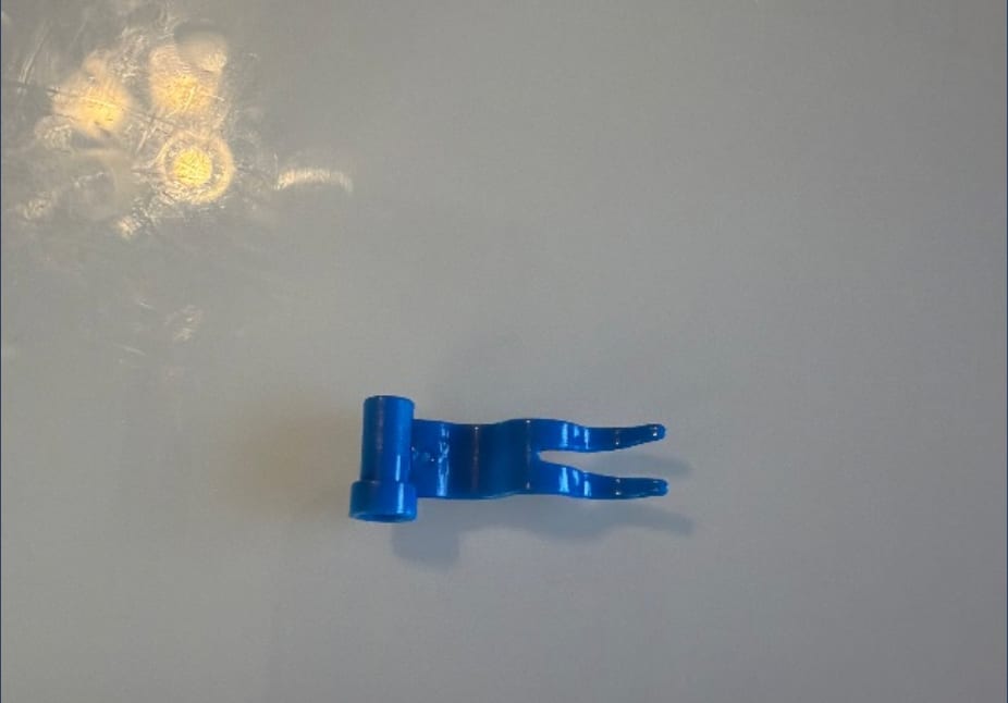 Blue LEGO Flag 4 x 1 Wave part lying alone on a plain light surface.